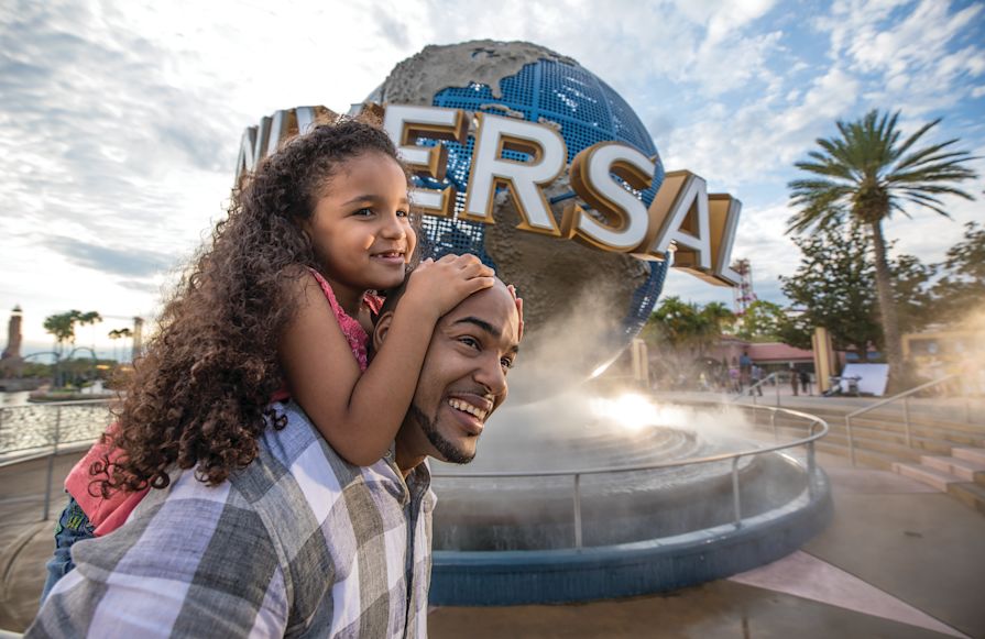 Tată ținând o fiică în fața unei Tranziții Universale a Globului