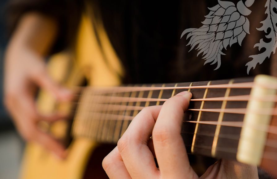 Thistle and Rye person playing guitar close-up on guitar-transition
