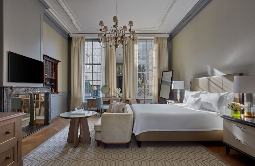 Large Bed, and Lounge Area in a Suite with TV and Large Windows-transition