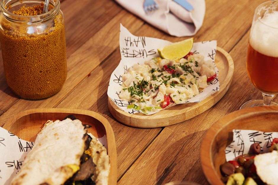 Çeşitli malzemeler, salsa ve bardaklar içeren Yunan pitiası ve sokak yiyecekleri.