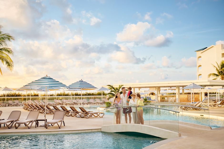 Family enjoying a day in outdoor pool area with lounge chairs