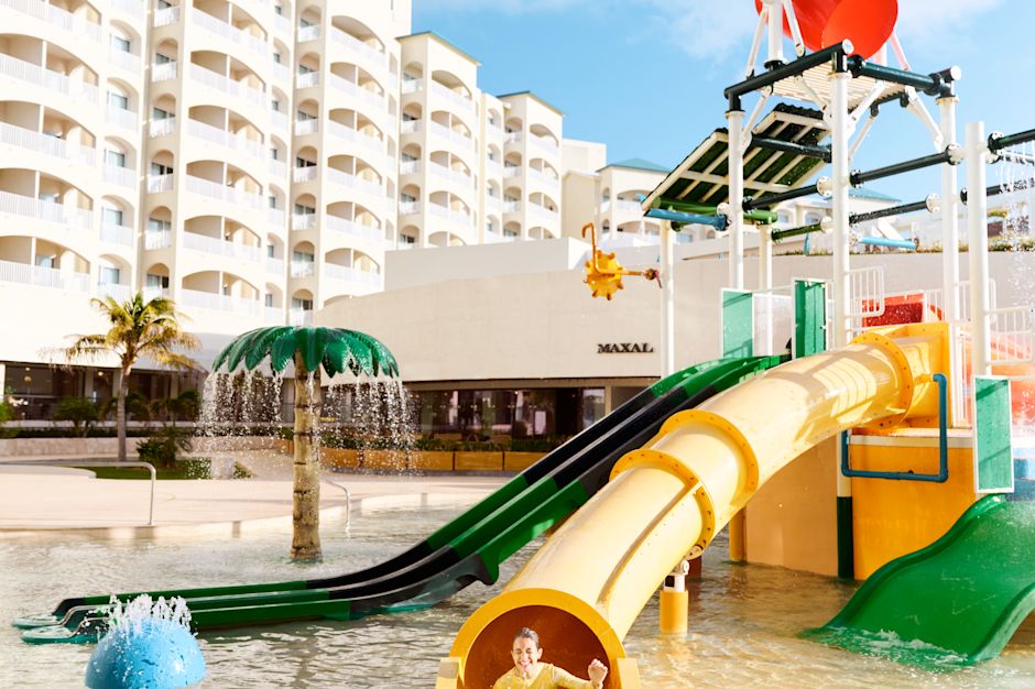 Girl enjoying a slide in a splash pool outdoors