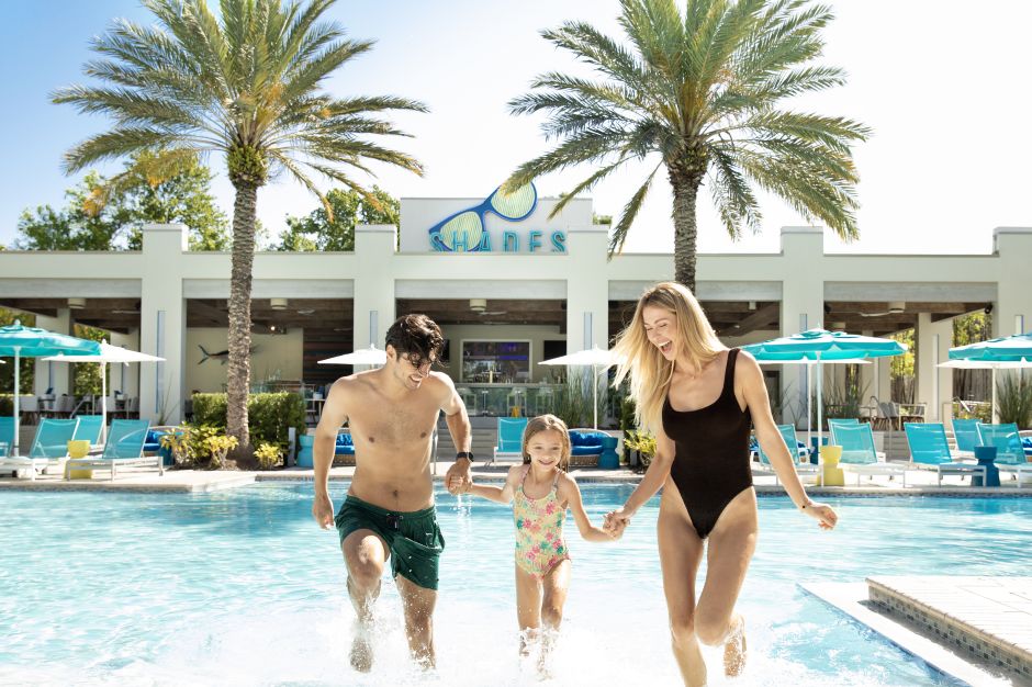 family playing in outdoor pool