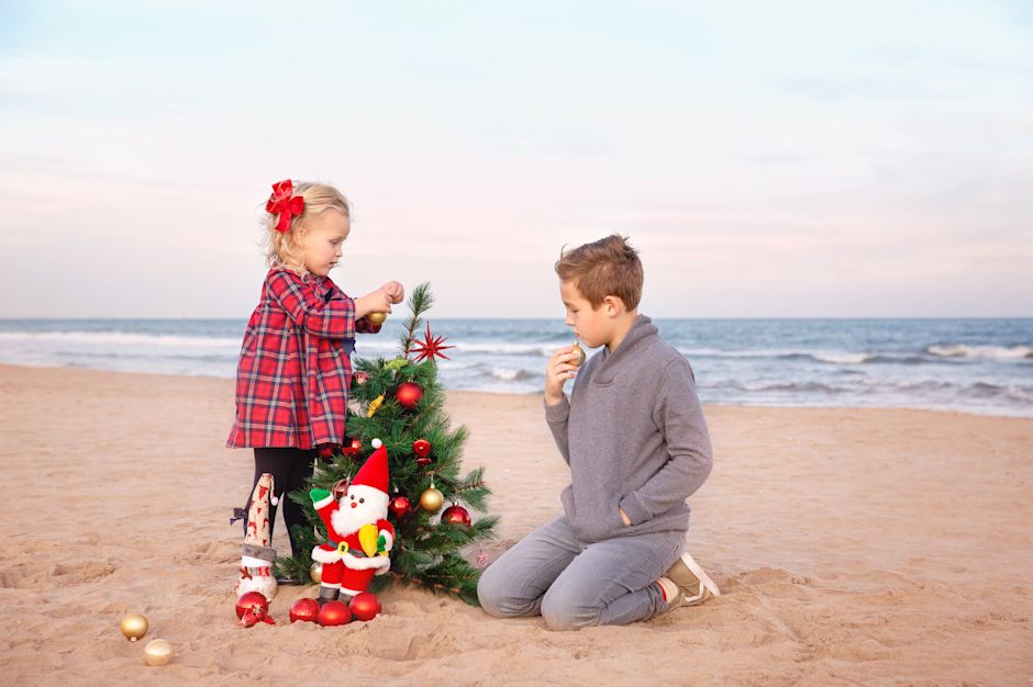 Enfants sur la plage avec sapin de Noël