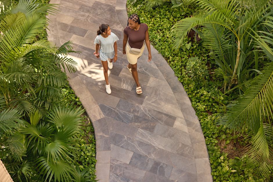 Moeder en dochter lopen over een pad in de hoteltuinen