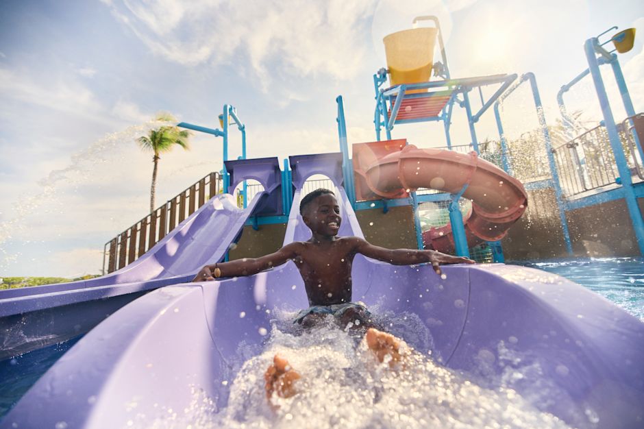 Boy racing down the giant waterslide in the Splash Zone
