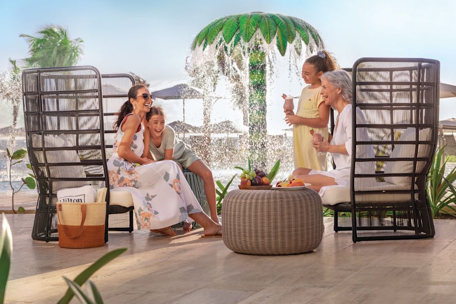 สมาชิกในครอบครัวที่นั่งดื่มเครื่องดื่มอยู่ใกล้ ๆ กับสวนน้ำ