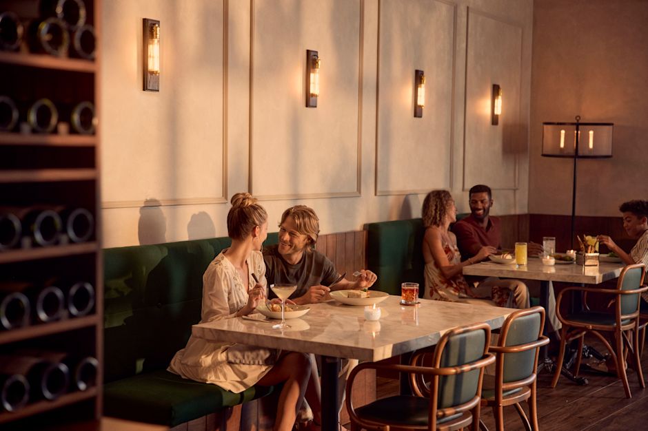 Un homme et une femme savourant un dîner et des boissons au restaurant de l'hôtel