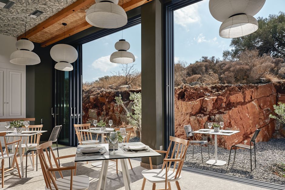 Griglia'nın açık hava yemek alanına bakan geniş pencerelerin yanında modern kapalı yemek alanı.
