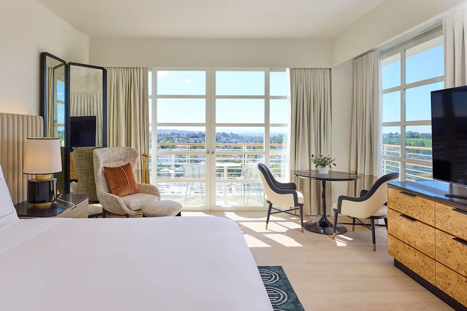 대형 침대, 좌석 공간 및 대형 창문이 있는 객실의 TV