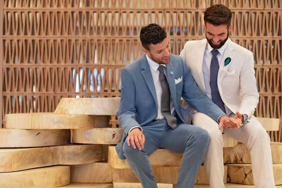 Two men in suits hold hands