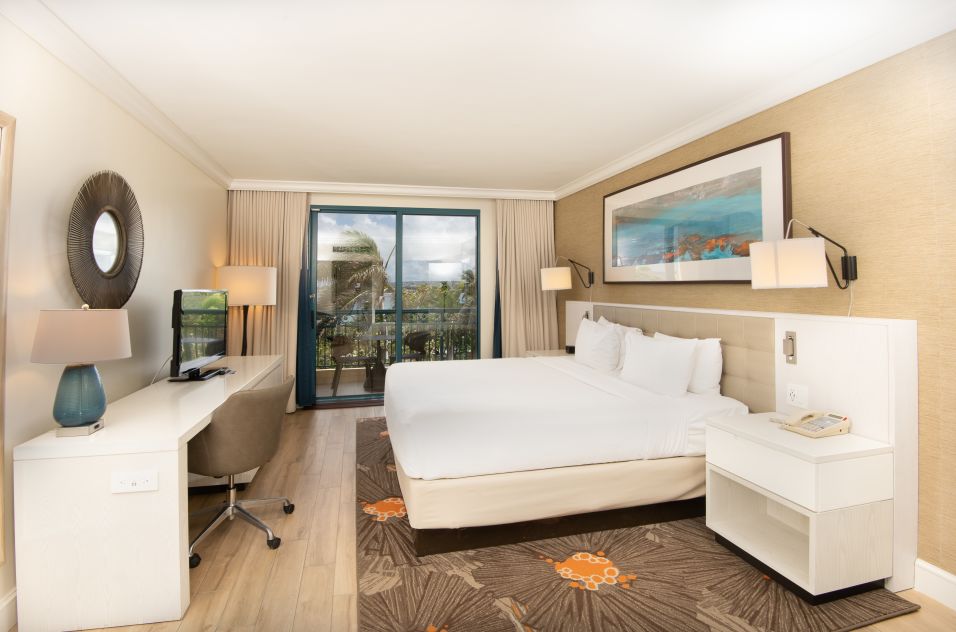 king bedroom with work desk and view of balcony