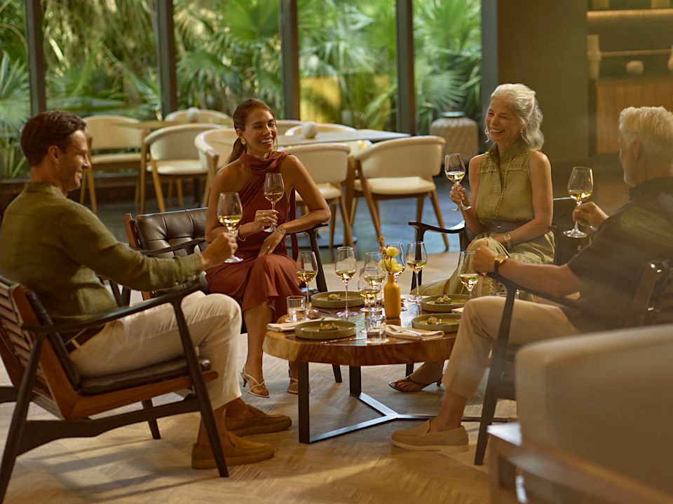 Pai, mãe e avós bebendo vinho branco e desfrutando de petiscos leves no Ceiba Club