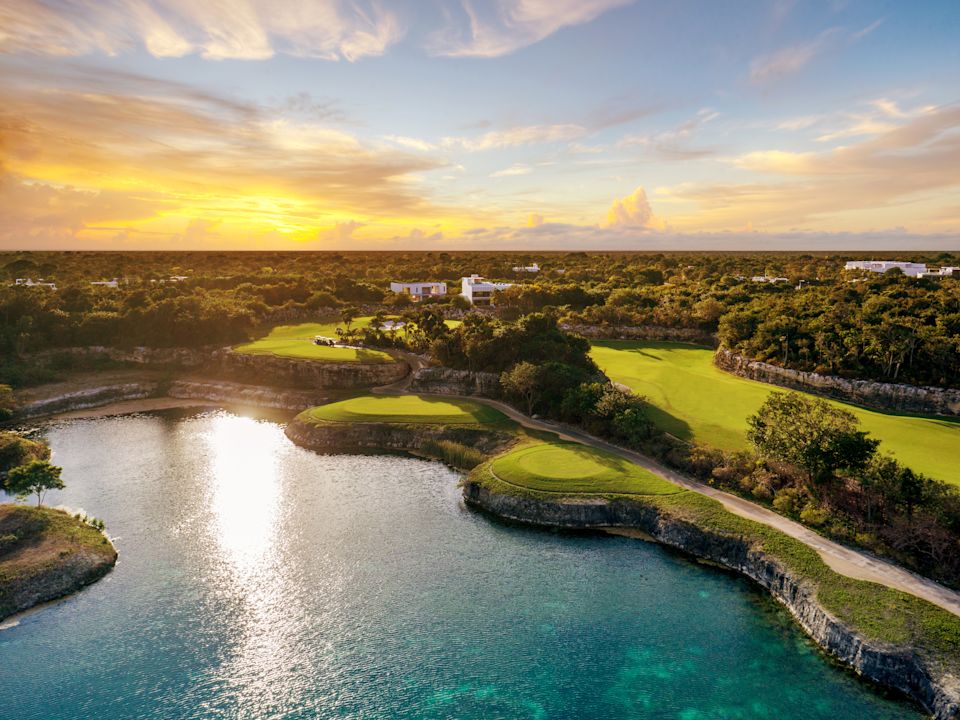 Aerial View of a Golf Course with Trees and a Water Feature at Sunset
