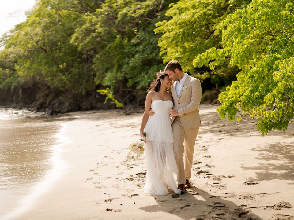 Wedding Couple walking along a tropical pristine beach