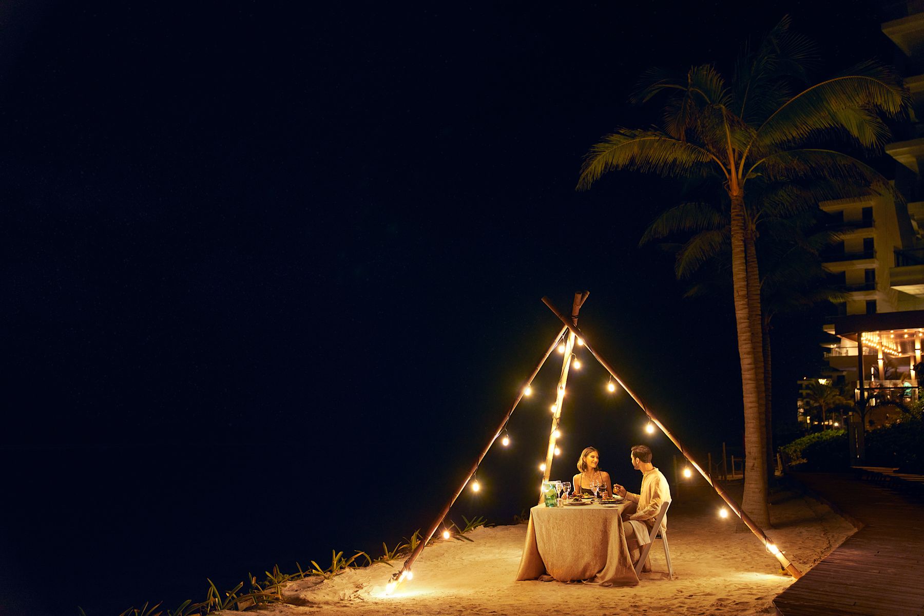 couple sitting at table on beach