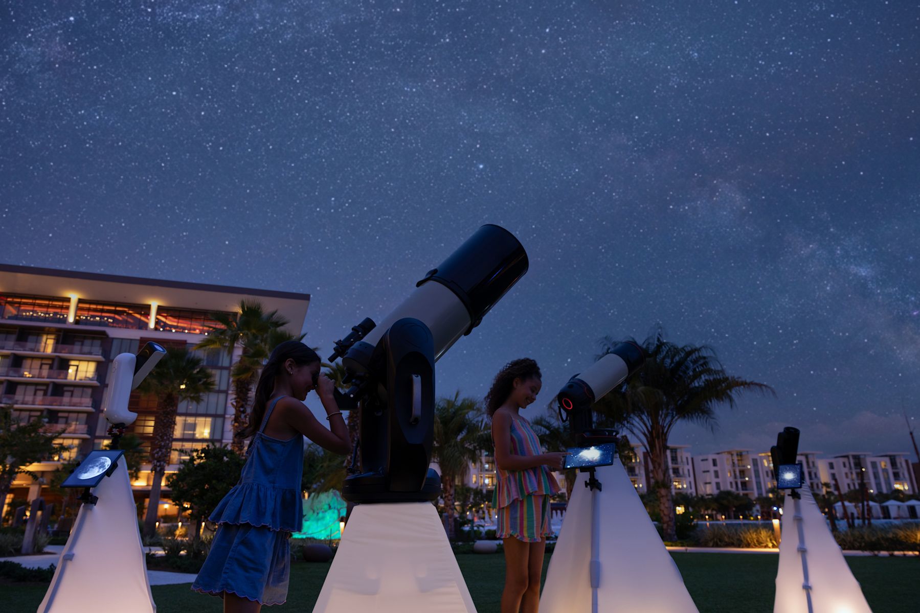 Family Looking at the Constellations with a Telescope at Night