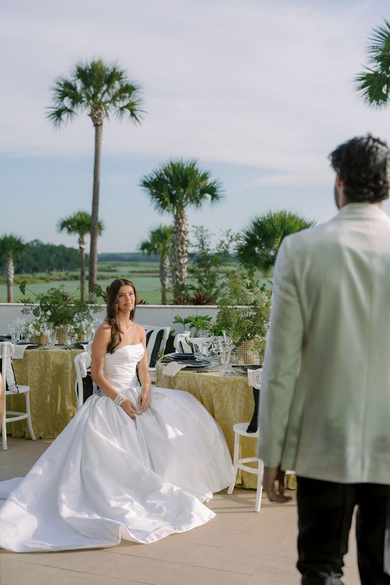 Mariage en robe de mariage assis à une table décorée, et le marié approche.