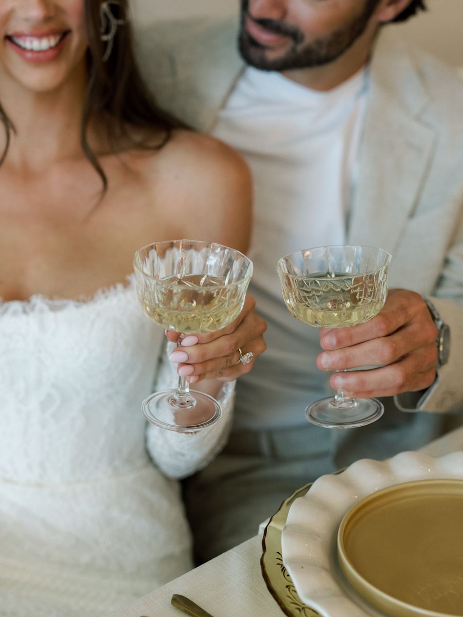 Couple pour le jour de leur mariage en train de boire un verre pour fêter 