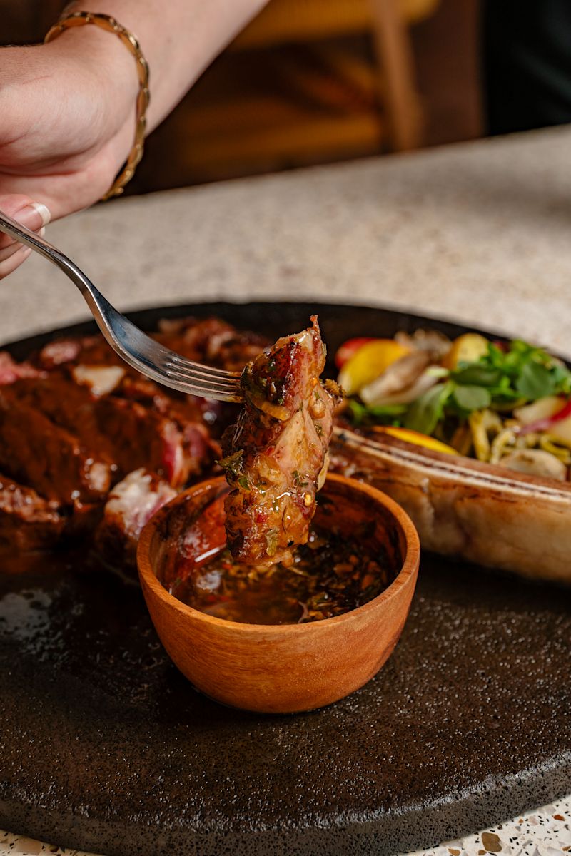 Woman Dining Steak with Sauce at Maxal Restaurant