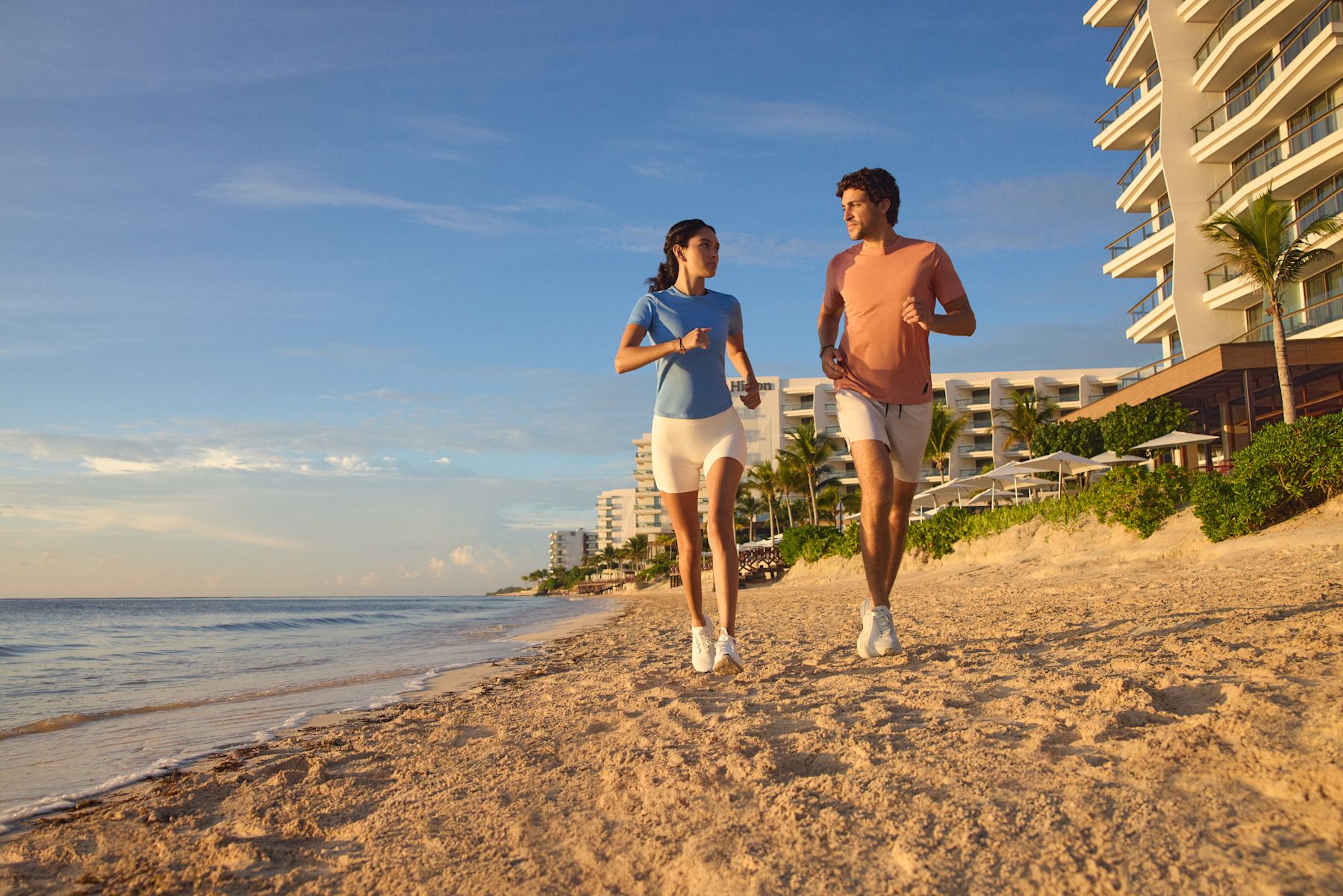 ホテルのビーチでジョギングをする男女