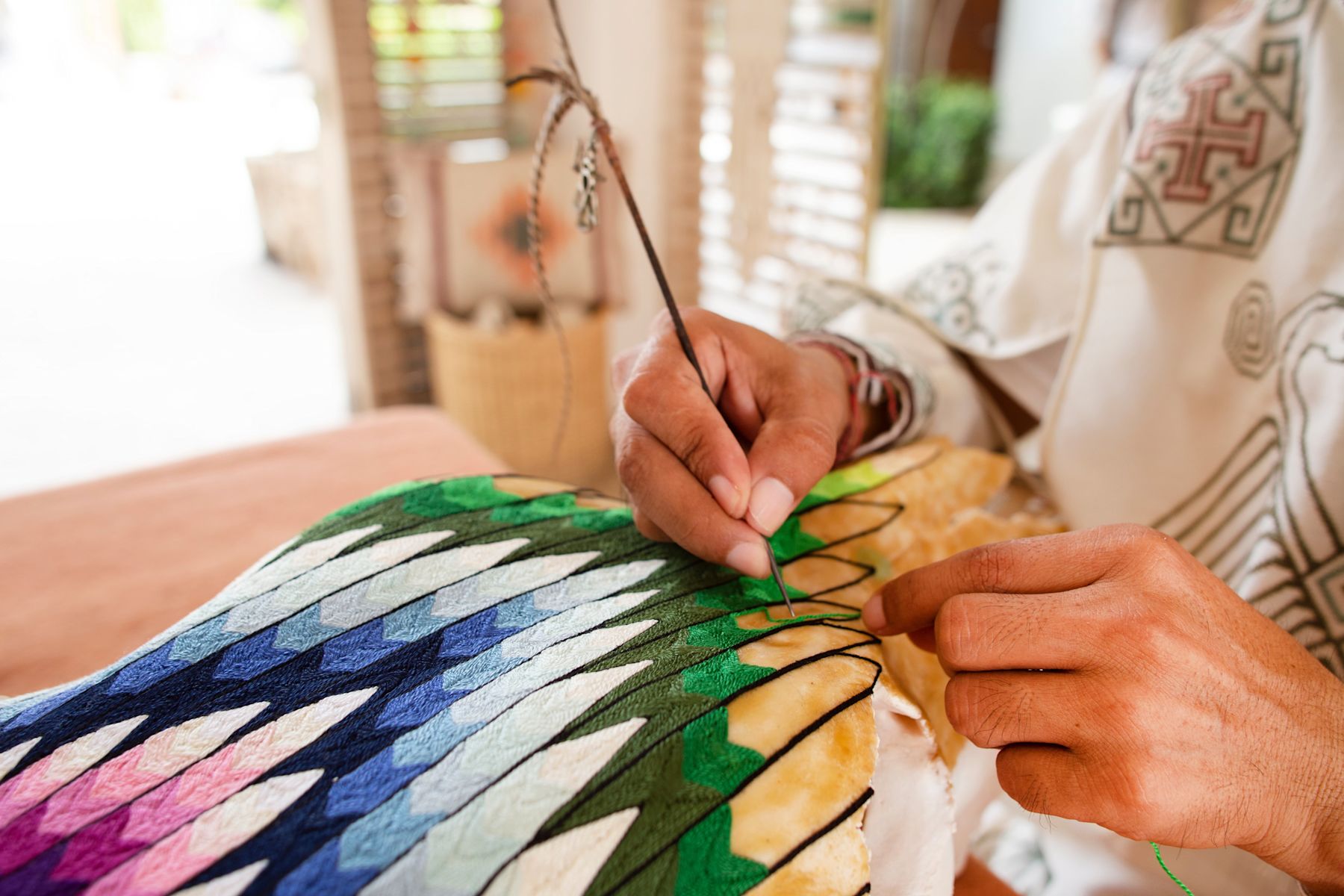 Femme cousant un tissu multicolore