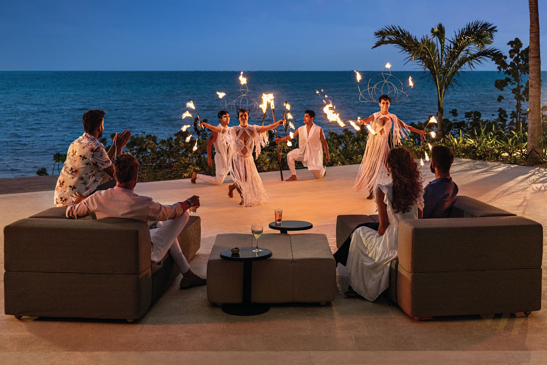 Group of people enjoying fire show outside by the beach