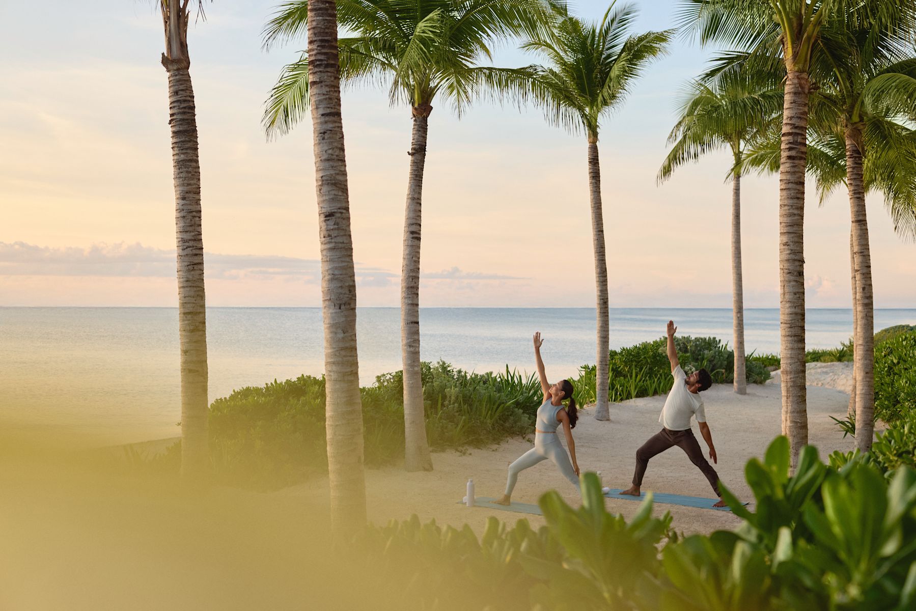Mann und Frau praktizieren Yoga am Strand
