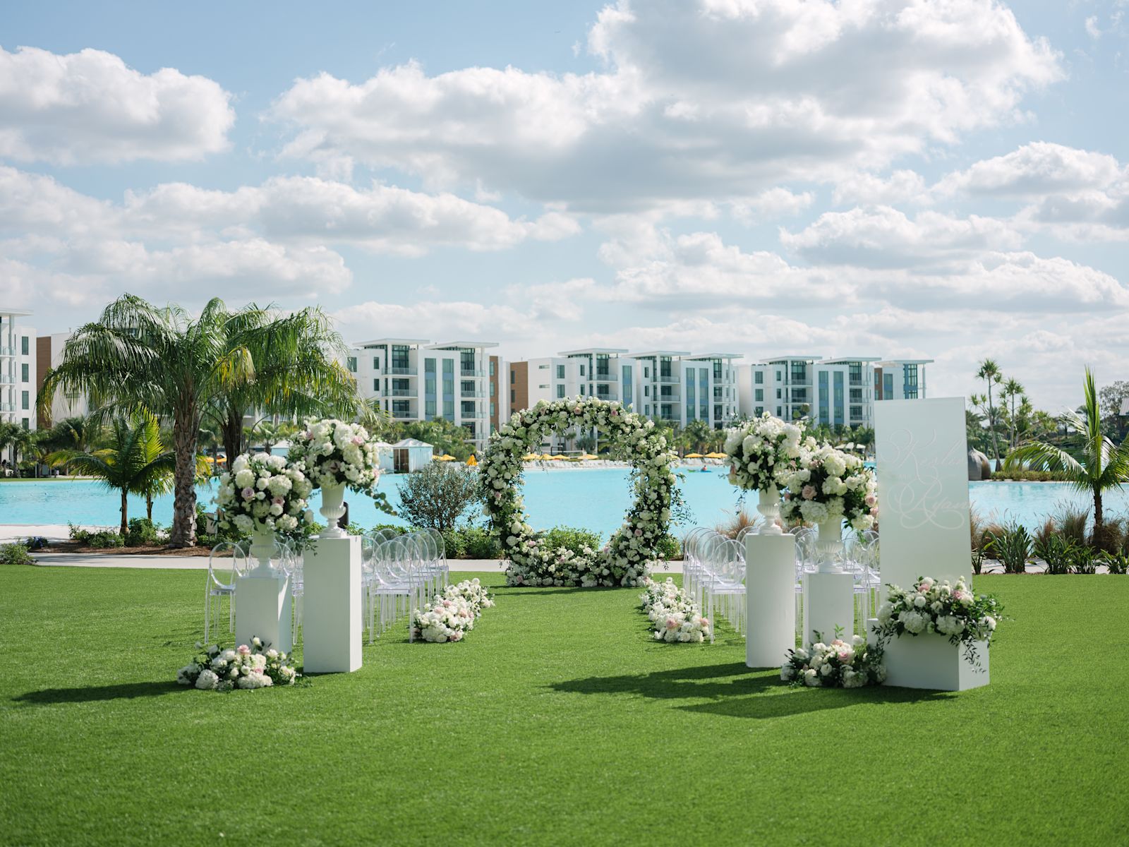 configuration cérémonie de mariage, cour extérieure, fleurs blanches et roses, vue sur la plage et l'extérieur de l'hôtel