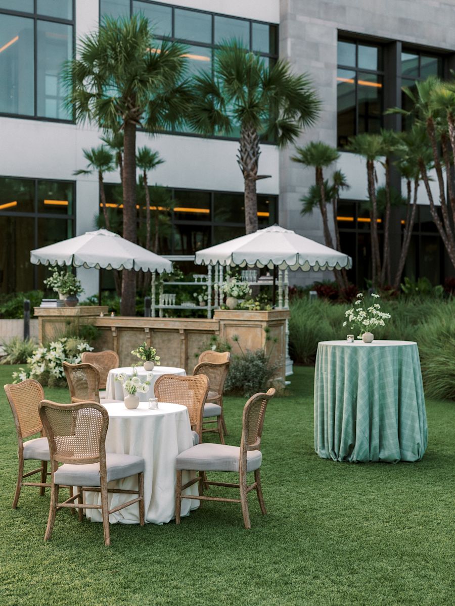 Tables et chaises installées sur la pelouse et prêtes pour un événement.