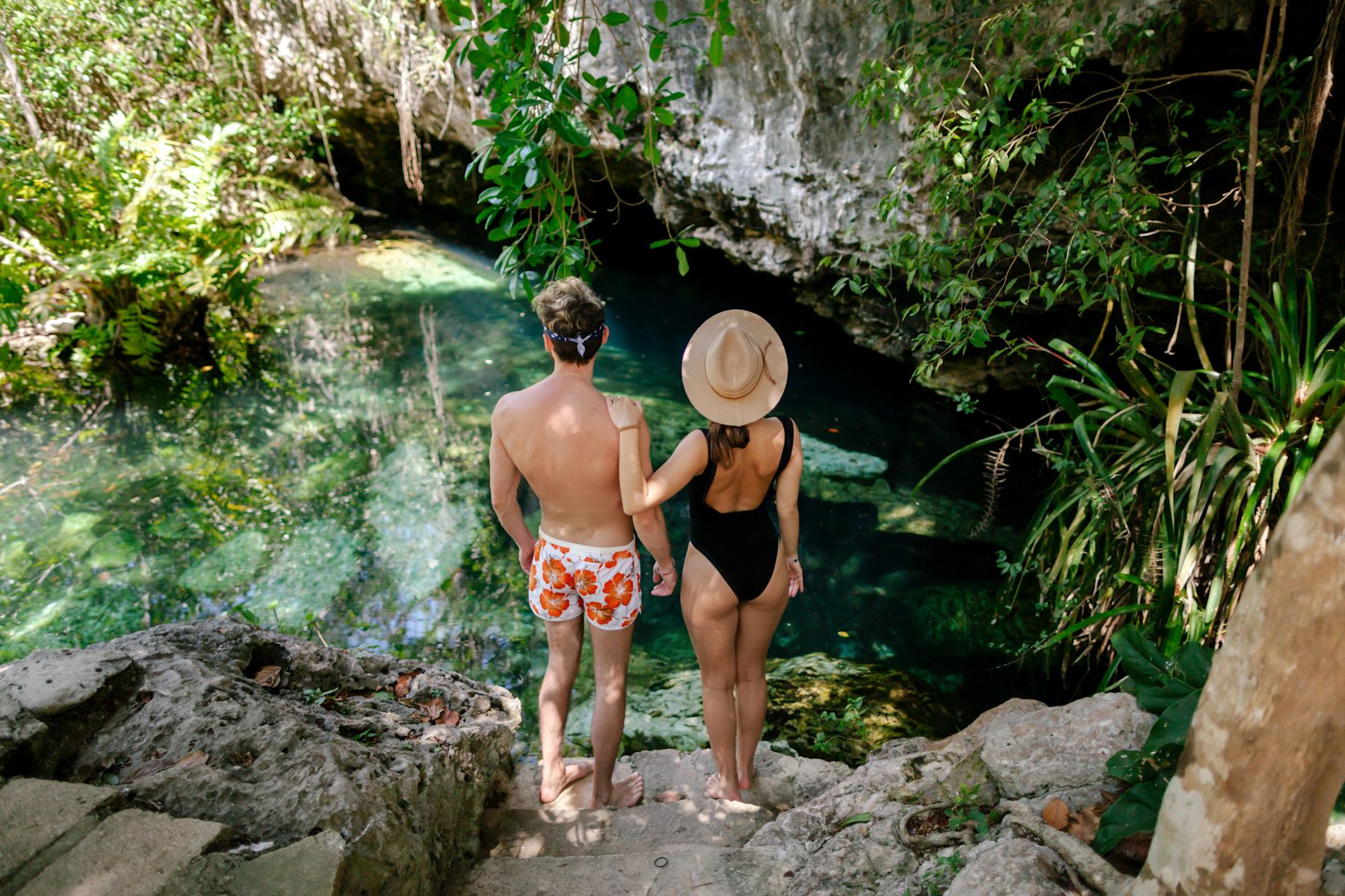man and woman standing on rocks overlooking water