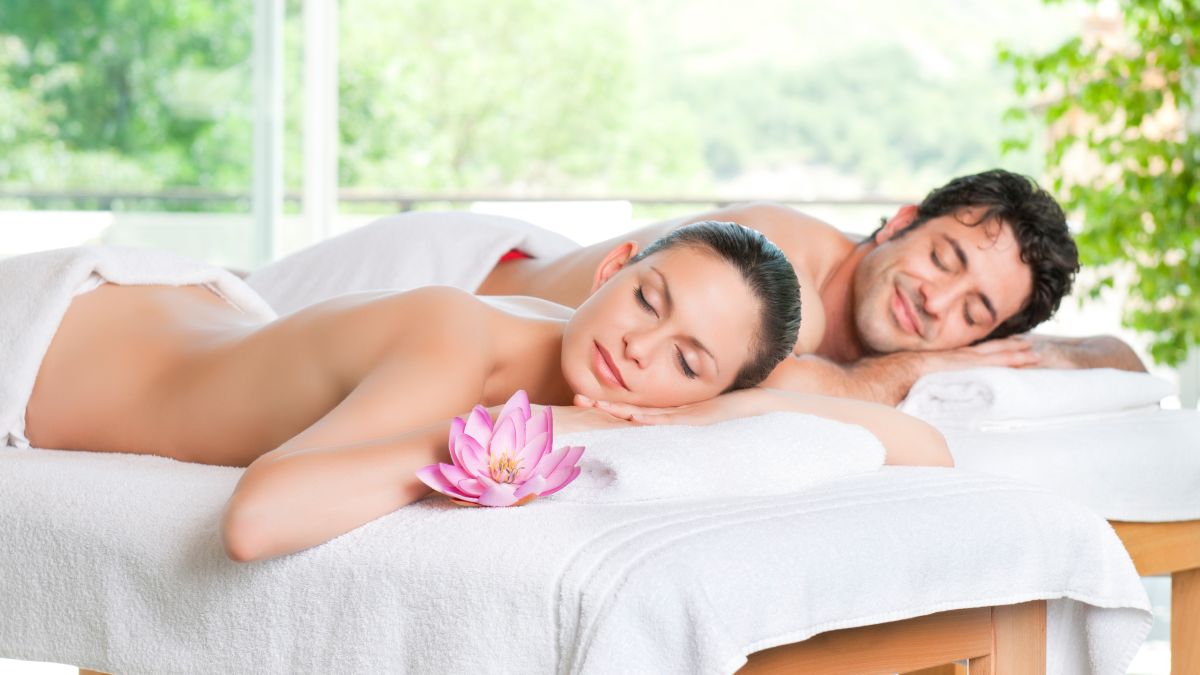 Couple lying on side-by-side massage tables