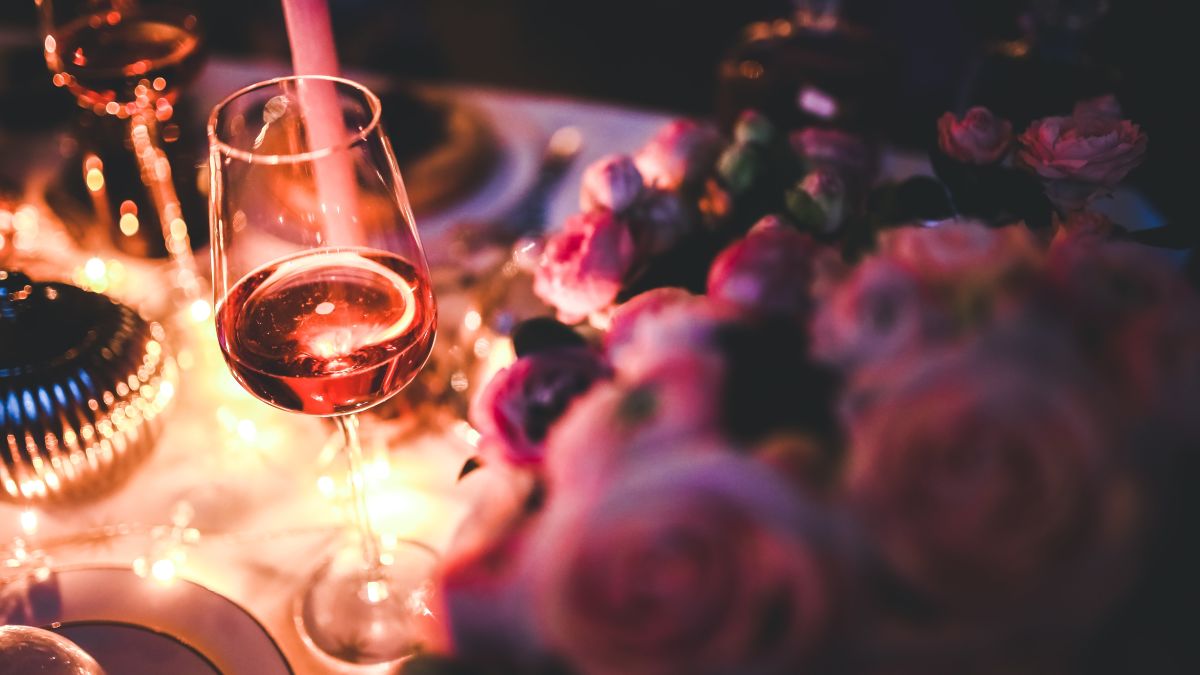 Closeup of a glass of wine and lit candle