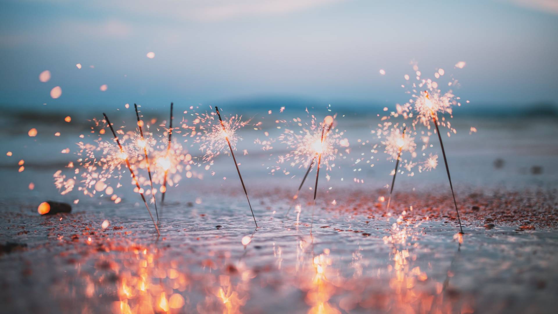 Sparklers stuck in the sand on the beach