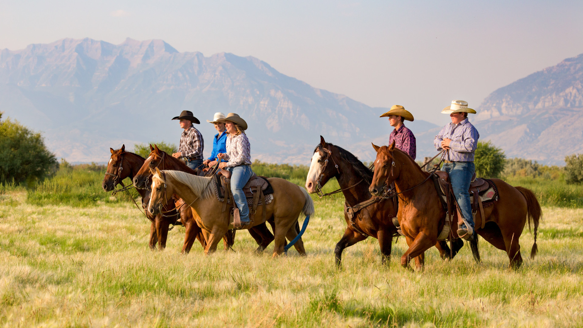 People riding horses with mountain backdrop