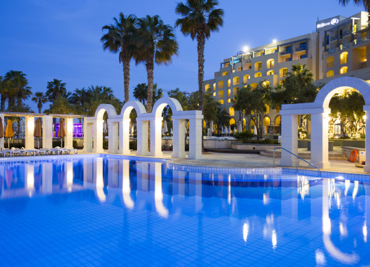 Outdoor pool details, palm trees, hotel exterior at night