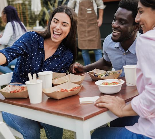 Multiracial people having fun doing selfie with mobile phone at food truck restaurant outdoor.