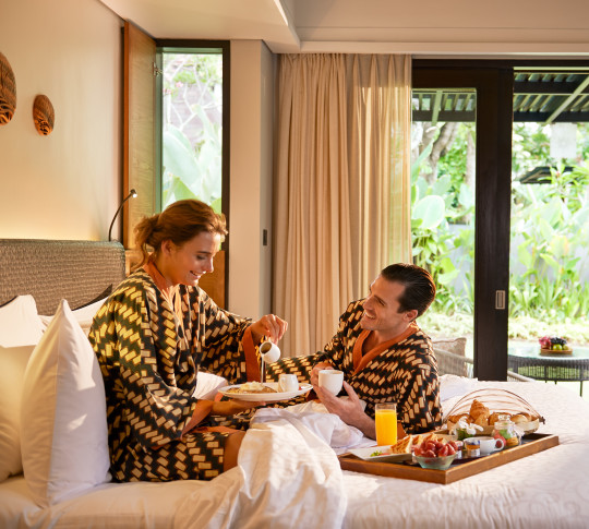 Guests in robes eating breakfast in bed
