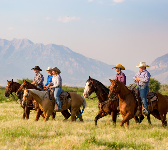 People riding horses with mountain backdrop