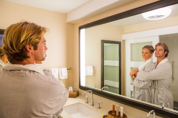 Couple in bathrobes looking in a mirror