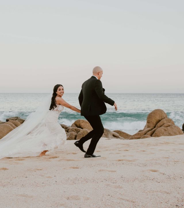 Bride & groom running on the beach