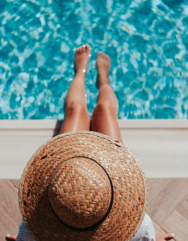 lady with a hat by the pool