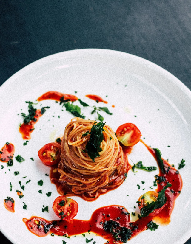 Tomato pasta elegantly presented on a plate.