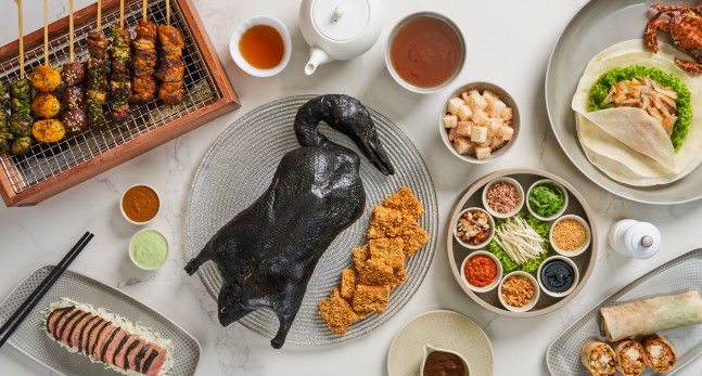 Traditional Asian cuisine laid out on a table including black truffle roasted duck.