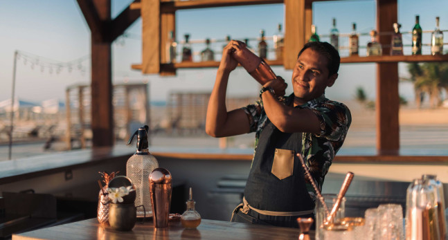 Bartender creating cocktail and Enclave Beach Bar
