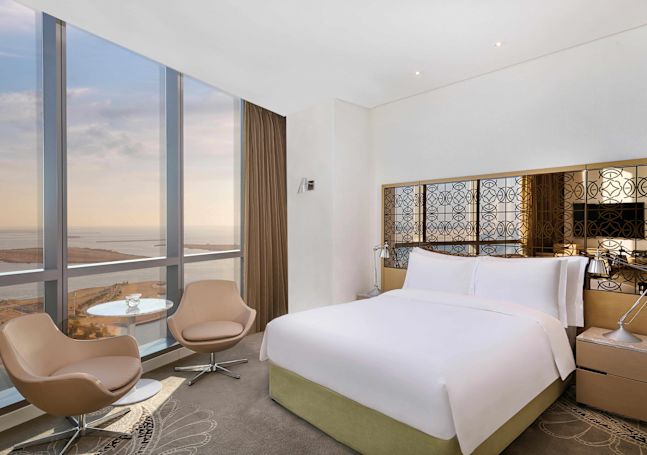bed in guestroom with seating and large window