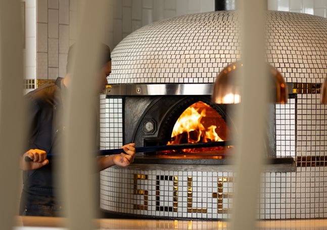 Chef cuisinant des pizzas dans un four au restaurant Sole