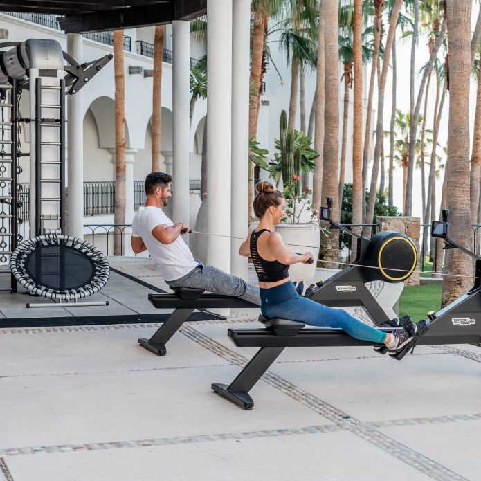 Cuplu studio de mișcare în aer liber folosind aparate de canotaj