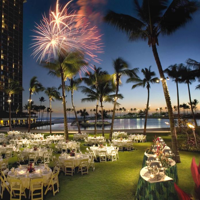 Outdoor event table setup with fireworks in sky