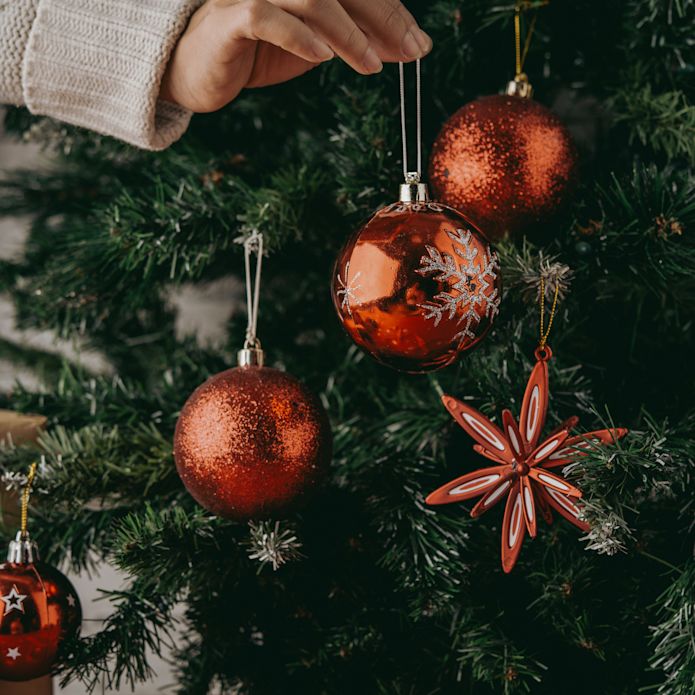 A Christmas ornament being hung on a tree
